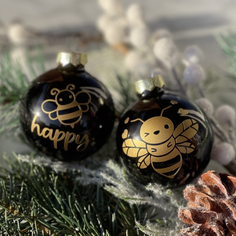 Schwarze Weihnachtskugeln mit Bienenmotiven in gold